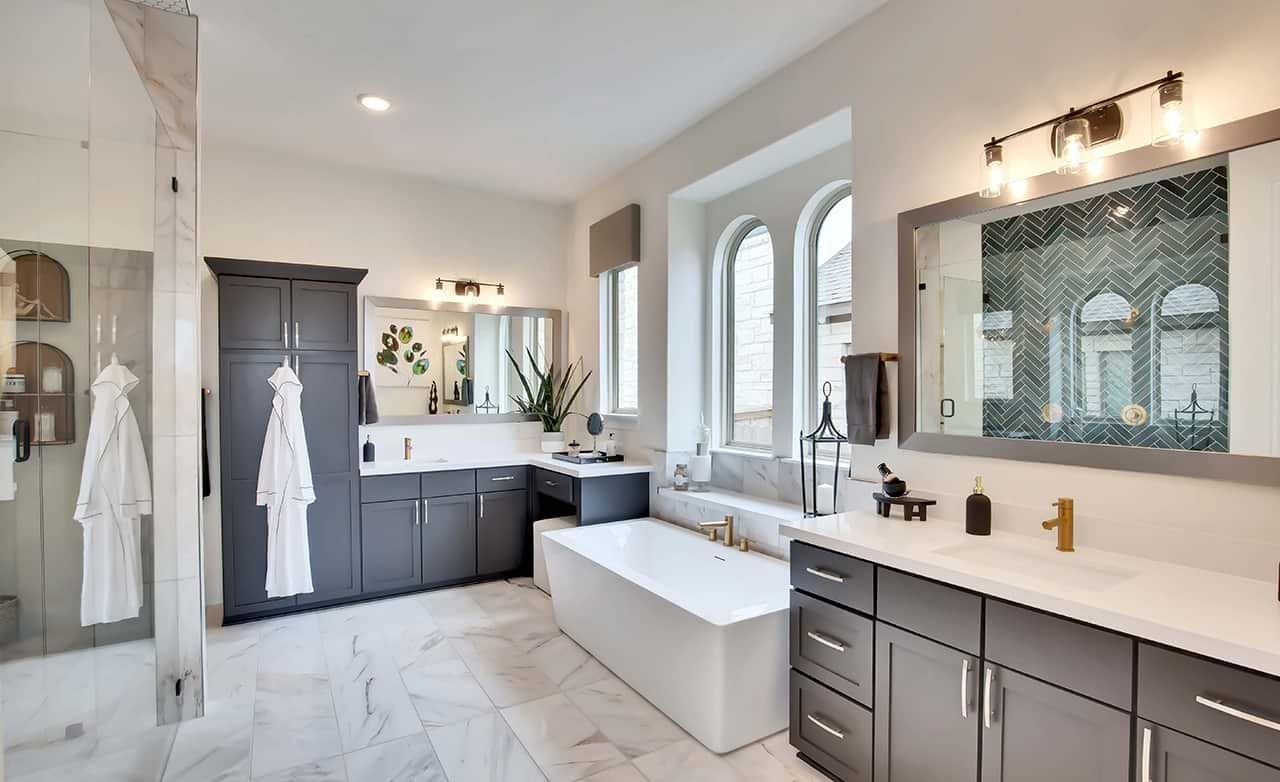 Elegant Bathroom Design in Oaks at San Gabriel, Texas Luxurious bathroom features freestanding tub, herringbone tile, and dark cabinets in Oaks at San Gabriel, Texas.