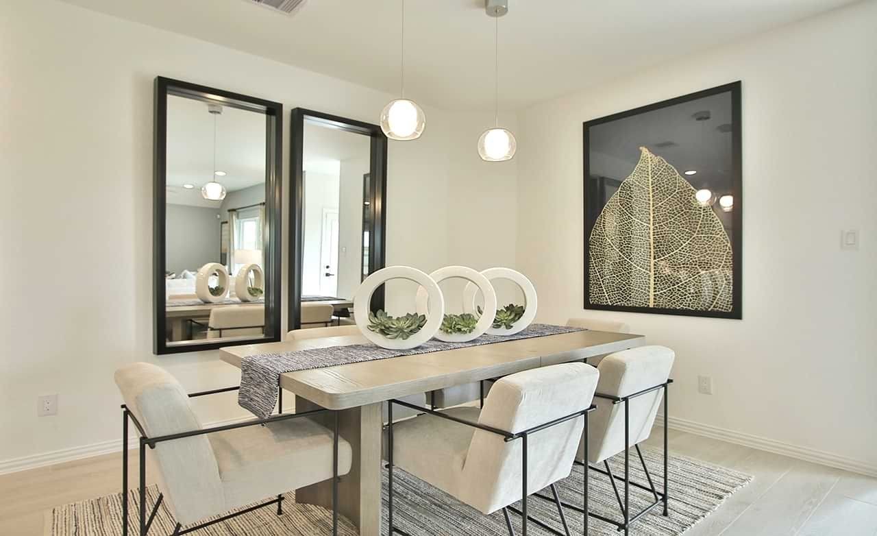 Dining Room in Oakwood Estates Featuring Contemporary Design and Art Modern dining room in Oakwood Estates with sleek table, light chairs, large leaf art, and mirrors.