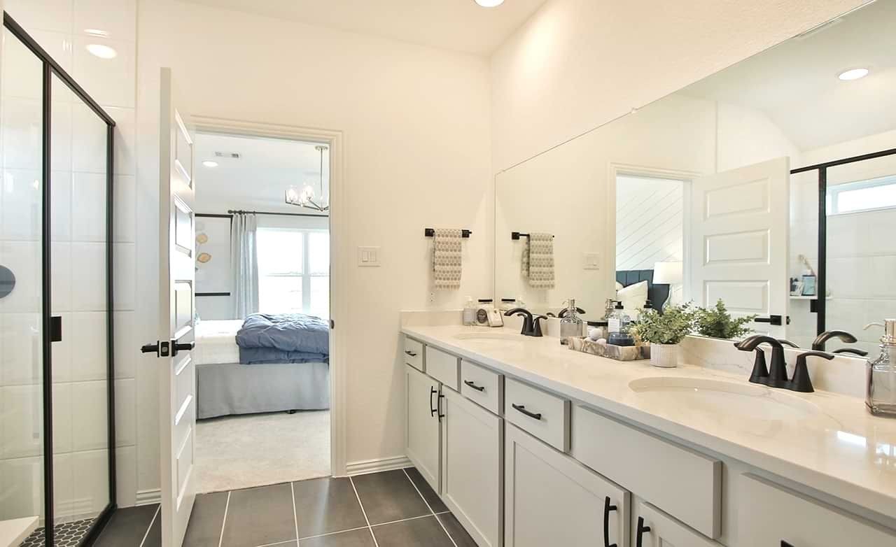 Oakwood Estates Bathroom with Double Vanity and Modern Fixtures Luxurious Oakwood Estates bathroom with double vanity, modern fixtures, and a glimpse of adjoining bedroom.