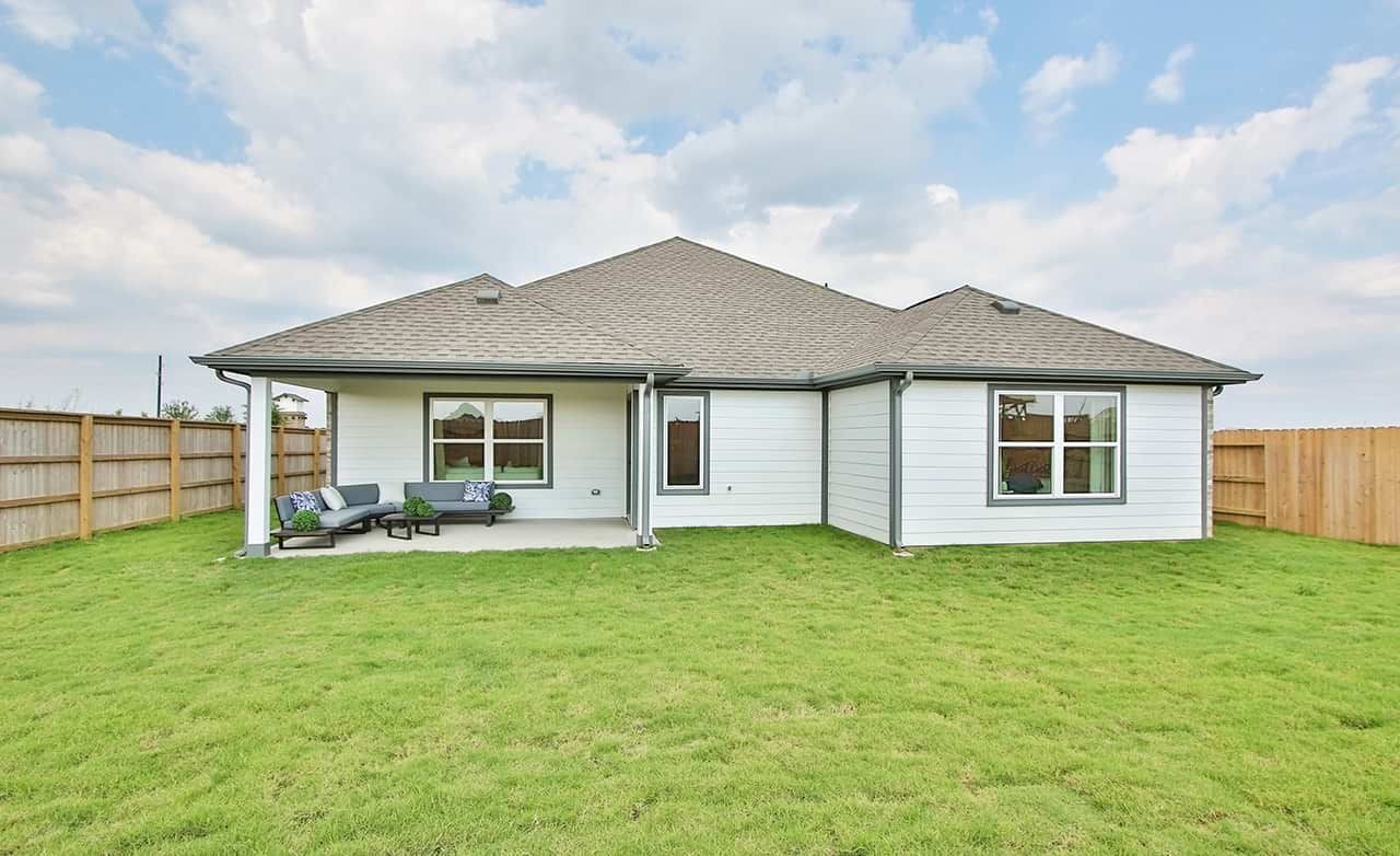 Modern Single-Story Home in Oakwood Estates with Spacious Lawn Modern white single-story house, gray roof, lush lawn, wooden fence, Oakwood Estates.