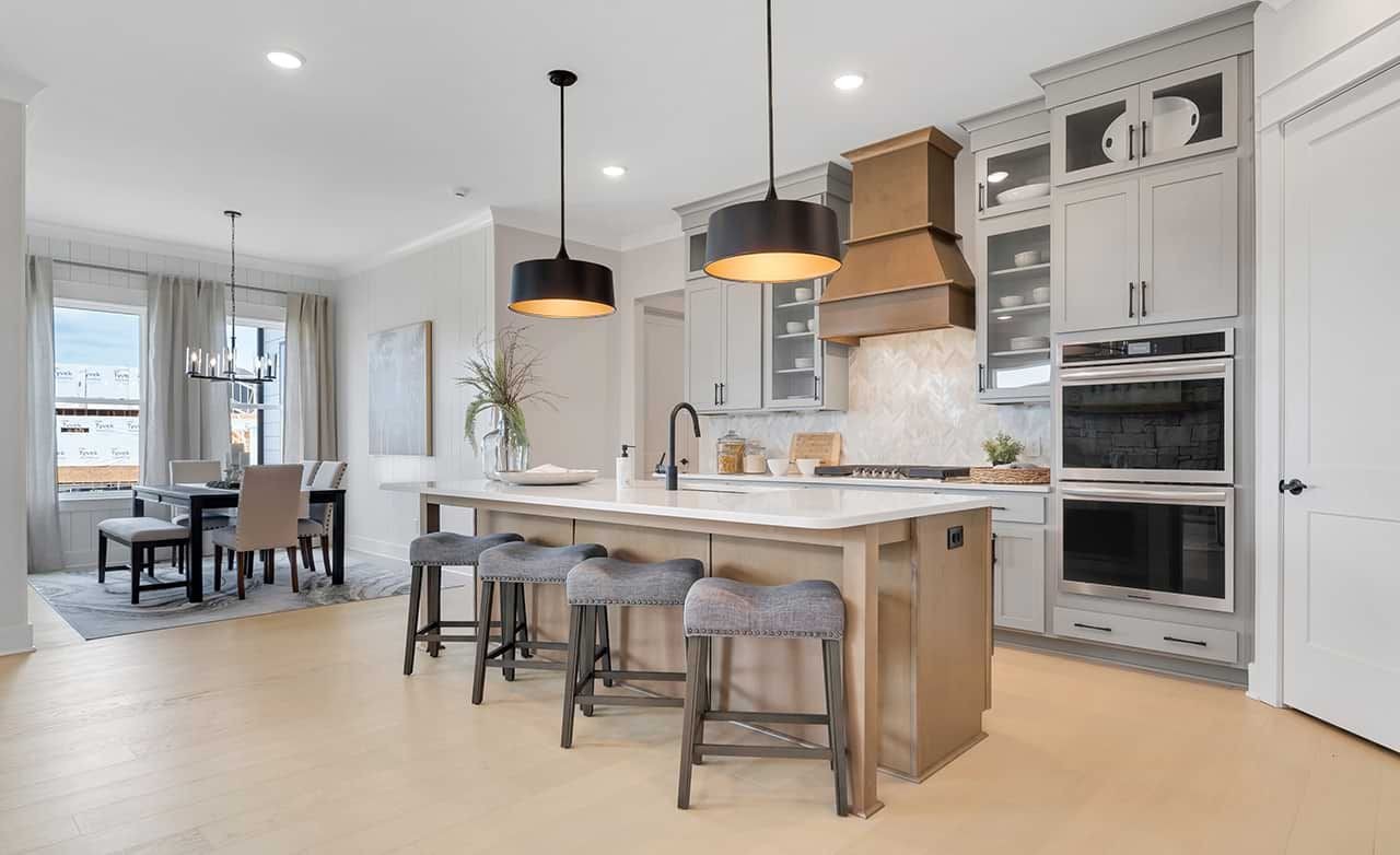 Luxury Kitchen with Island and Dining Area in Richvale Estates Modern kitchen with island, pendant lights, and stainless appliances in Richvale Estates. Light wood flooring.