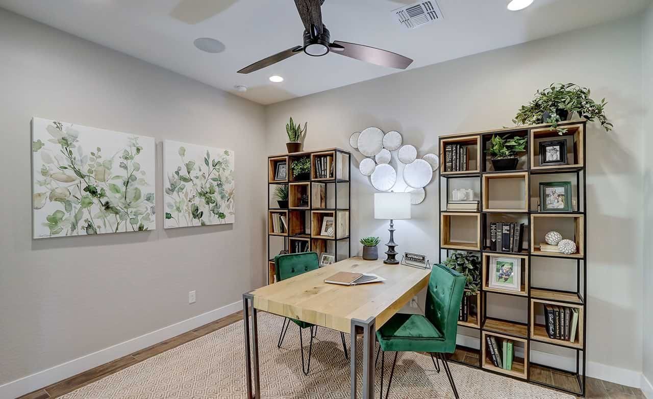 Home Office Design at The Lakes at Rancho El Dorado Elegant home office at The Lakes at Rancho El Dorado with wooden desk, shelving, and botanical artwork.