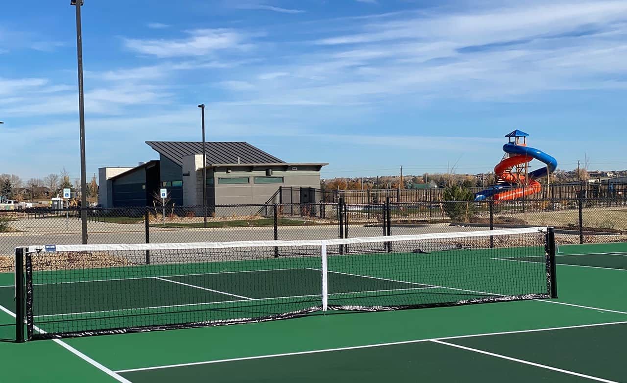 Tennis Court and Clubhouse at Trailside on Harmony, Colorado Tennis court with modern clubhouse and colorful slide in Trailside on Harmony, Colorado.