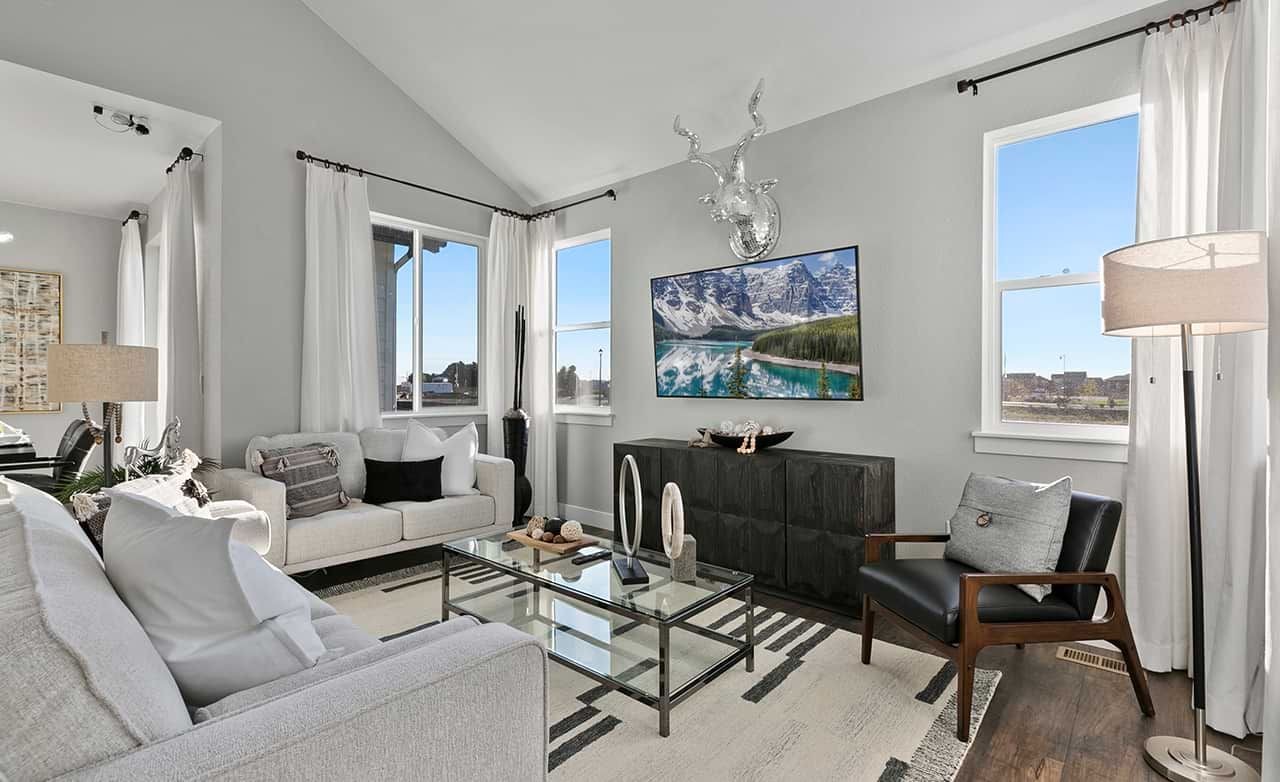 Modern Living Room with Vaulted Ceiling in Trailside on Harmony Modern living room with vaulted ceiling, glass coffee table, and scenic artwork in Trailside on Harmony.