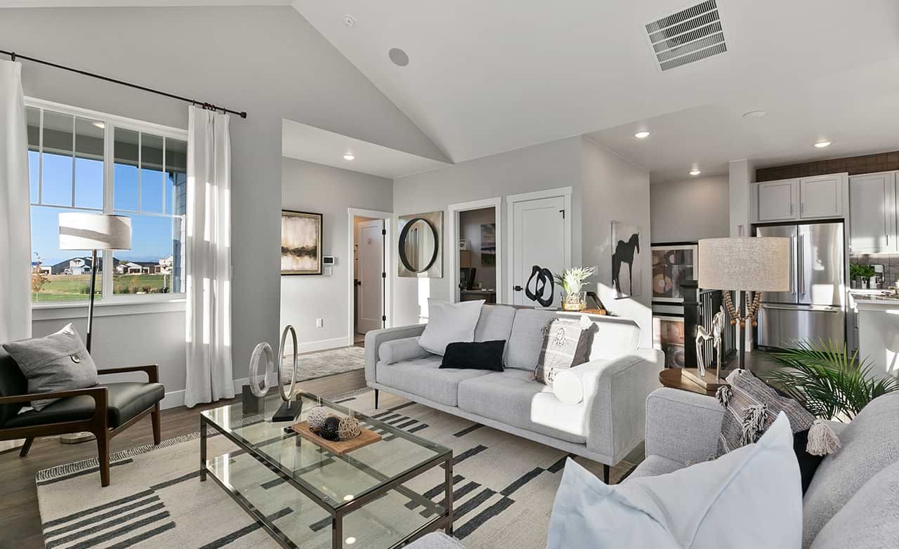 Elegant Living Room Design at Trailside on Harmony, Colorado Modern living room with vaulted ceiling, glass coffee table, and large window, Trailside on Harmony, Colorado.