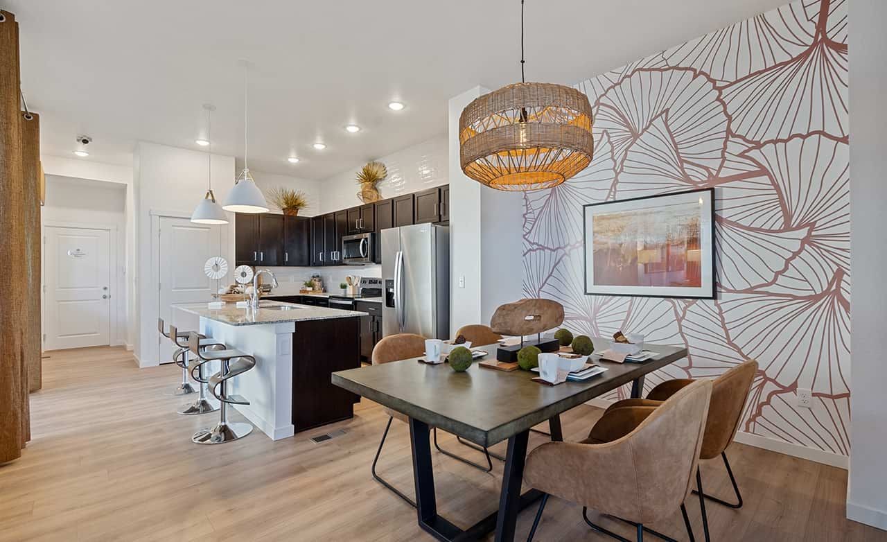 Modern Kitchen and Dining Area in Trailside on Harmony Modern kitchen and dining area with island, pendant lights, and unique floral accent wall, Trailside on Harmony.