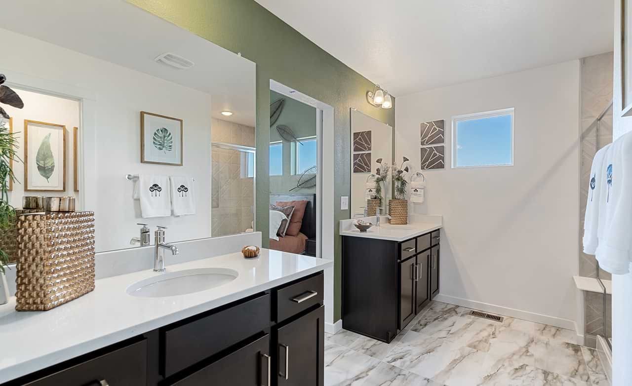 Luxurious Bathroom with Double Vanity in Trailside on Harmony Modern bathroom with double vanity, dark wood cabinets, marble floor in Trailside on Harmony community.